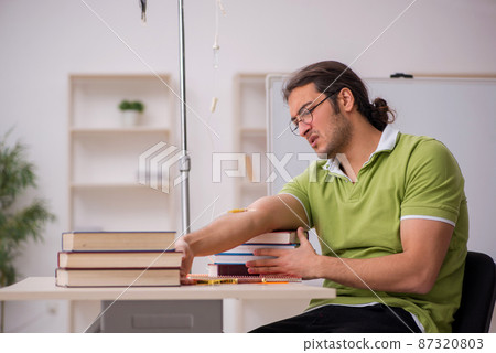 Young sick male teacher student in blood transfusion concept Young sick male teacher student in blood transfusion concept 87320803