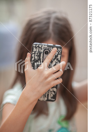 Hand holds a smartphone in a fashionable stylish case Hand holds a smartphone in a fashionable stylish case 87321175