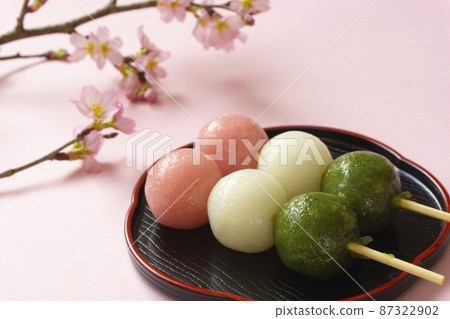 Japanese sweets. Three-color dumplings and cherry blossoms Japanese sweets. Three-color dumplings and cherry blossoms 87322902