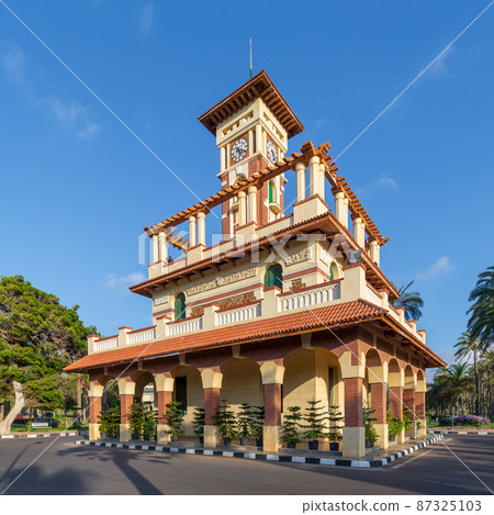 Clock tower in Montaza public park with decorated stone wall, green wooden window shutters, and red tile canopies, Alexandria, Egypt Clock tower in Montaza public park with decorated stone wall, green wooden window shutters, and red tile canopies, Alexandria, Egypt 87325103
