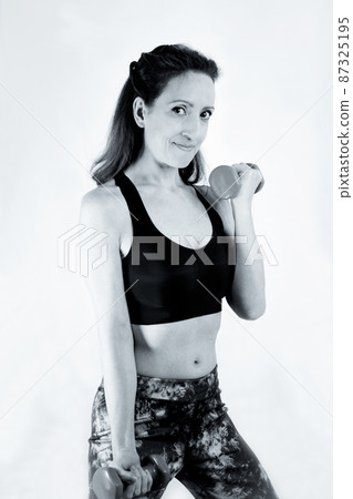 40 year old woman doing sports with weights 87325195