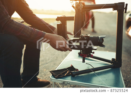 content creator setting stabilizer gimbal equipment camera for shoot video footage 87325524