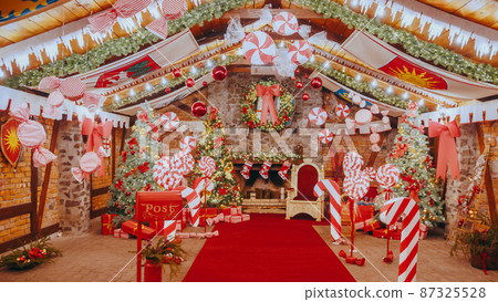 Red post box for letters to Lapland to Santa Claus. Christmas tradition. Decorative mailbox Santa Claus workshop, wrapped gifts presents boxes on holiday eve in night on xmas background 87325528