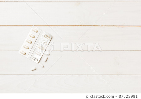 Protective face masks or surgical masks, medicine pills and thermometer on table background. Coronavirus disease. Corona virus concept. Space for text 87325981