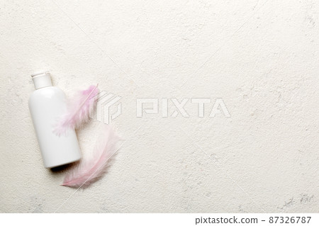 Set of skin care serums on pink pastel background with ostrich feathers. Spa cosmetic product, cream jar, branding mock up, top view with copy space 87326787