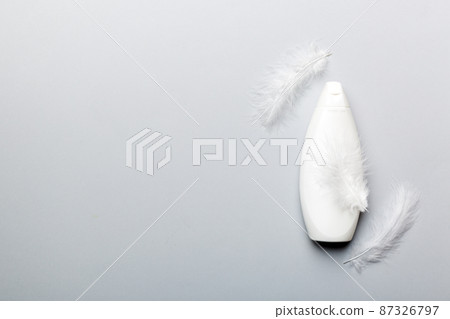 Set of skin care serums on pink pastel background with ostrich feathers. Spa cosmetic product, cream jar, branding mock up, top view with copy space 87326797