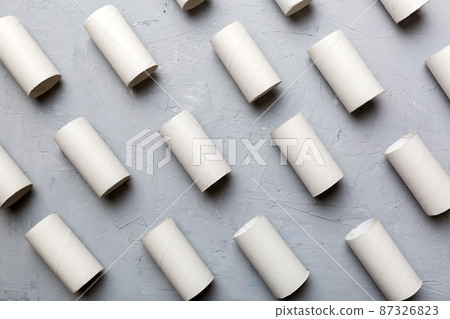 Empty toilet paper roll on colored background. Recyclable paper tube with metal plug end made of kraft paper or cardboard Empty toilet paper roll on colored background. Recyclable paper tube with metal plug end made of kraft paper or cardboard 87326823