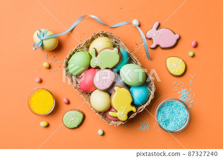 Colorful easter cookies in basket with Multi colors Easter eggs on colored background . Pastel color Easter eggs. holiday concept with copy space Colorful easter cookies in basket with Multi colors Easter eggs on colored background . Pastel color Easter eggs. holiday concept with copy space 87327240