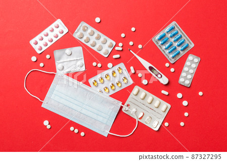 Protective face masks or surgical masks, medicine pills and thermometer on table background. Coronavirus disease. Corona virus concept. Space for text 87327295