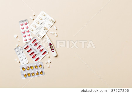 Protective face masks or surgical masks, medicine pills and thermometer on table background. Coronavirus disease. Corona virus concept. Space for text 87327296