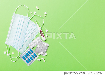 Protective face masks or surgical masks, medicine pills and thermometer on table background. Coronavirus disease. Corona virus concept. Space for text 87327297
