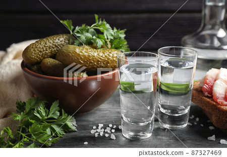 Cold Russian vodka with snacks on wooden table Cold Russian vodka with snacks on wooden table 87327469