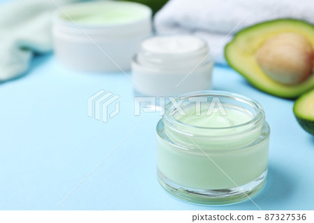 Open jar of cream on blue background. Space for text Open jar of cream on blue background. Space for text 87327536