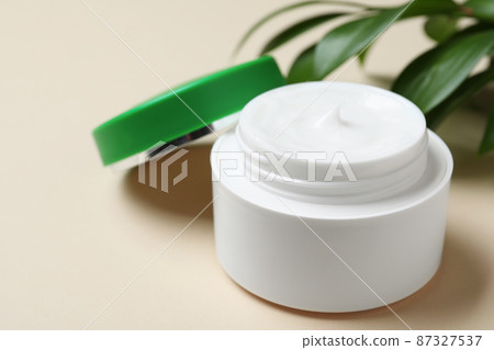 Open jar of cream on beige background, closeup Open jar of cream on beige background, closeup 87327537