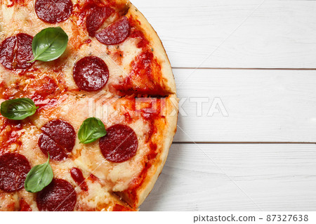 Hot delicious pepperoni pizza on white wooden table, top view. Space for text Hot delicious pepperoni pizza on white wooden table, top view. Space for text 87327638