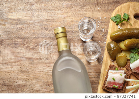 Flat lay composition with cold Russian vodka on wooden table, space for text 87327741