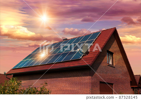 Photo collage of solar panels, photovoltaics on the red roof of a house and a beautiful sky with the setting sun. Alternative electricity source. Concept of sustainable resources Photo collage of solar panels, photovoltaics on the red roof of a house and a beautiful sky with the setting sun. Alternative electricity source. Concept of sustainable resources 87328145