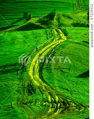 Dirt road located among the hills 87329352
