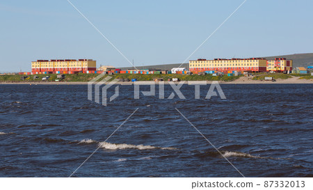 View of the coastal arctic settlement. Colorful buildings in the tundra on the shore 87332013