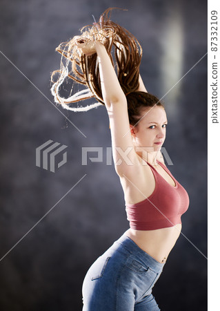 White woman 28 years old with in tank top and with dreadlock african braids indoors. 87332109