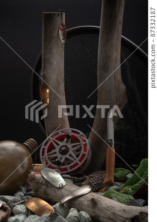 Fishing still life. Old vintage fishing tackle. Old baits and tackle for fishing. Tackle on rocks and wood. Fishing still life. Old vintage fishing tackle. Old baits and tackle for fishing. Tackle on rocks and wood. 87332187