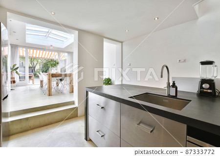 Luxury kitchen in a minimalist style with a black countertop Luxury kitchen in a minimalist style with a black countertop 87333772