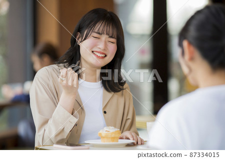 Young woman eating sweets at a cafe 87334015