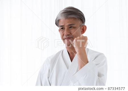 Middle-aged male martial artist wearing a dogi Middle-aged male martial artist wearing a dogi 87334577