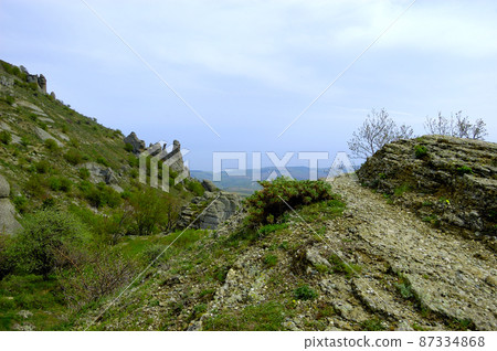 Horizontal background with a magnificent landscape of the Crimean Peninsula. Top view of the mountains covered with lush greenery and the thick clouds below the peaks. Clear blue sky. Copy space. Horizontal background with a magnificent landscape of the Crimean Peninsula. Top view of the mountains covered with lush greenery and the thick clouds below the peaks. Clear blue sky. Copy space. 87334868