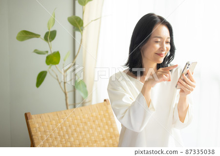A woman watching a smartphone 87335038