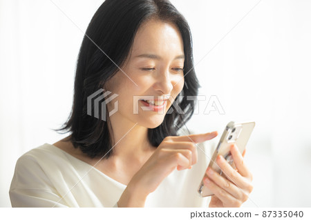 觀看智能手機的婦女 觀看智能手機的婦女 87335040