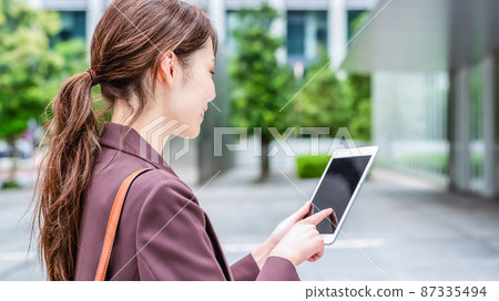 Business woman manipulating tablet 87335494