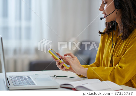 Young woman in a mustard shirt looking busy 87335787
