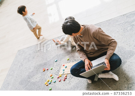 Daddy working from home while taking care of children Daddy working from home while taking care of children 87336253