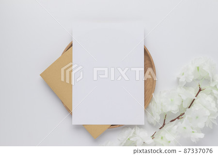 Blank greeting card invitation Mockup on Brown envelope with Dried bunny tails grass on white background, Minimal table workplace composition, flat lay, mockup 87337076