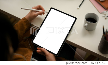 Female using stylus pen with digital tablet, designing her graphic works. Female using stylus pen with digital tablet, designing her graphic works. 87337152