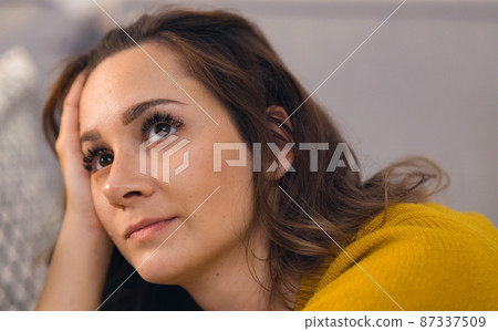 Young pretty woman immersed in thoughts Young pretty woman immersed in thoughts 87337509