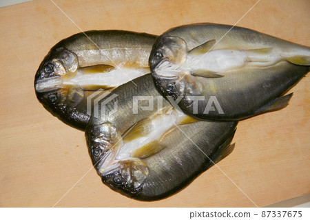 Dried sweetfish with an open back. Three pictures were taken on a cutting board in the raw state before the trouble. 87337675