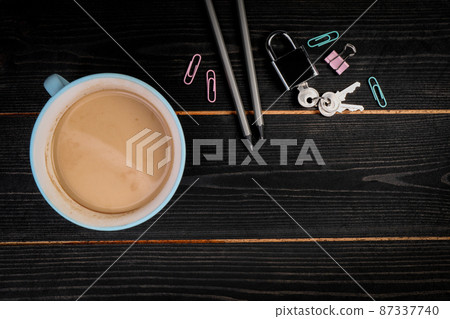 Copy Space. Dark wood texture background. Coffee mug, padlock and stationery Copy Space. Dark wood texture background. Coffee mug, padlock and stationery 87337740