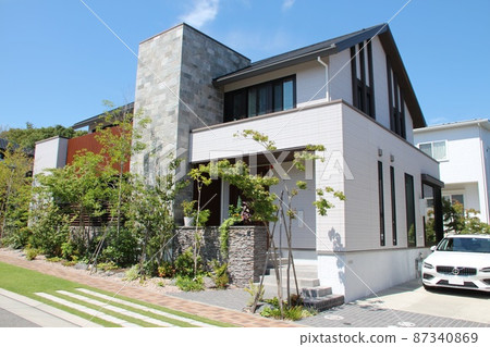 A luxurious and stylish detached house with beautiful white walls and stone accent walls that shine in the blue sky. 87340869
