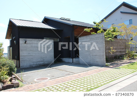 一座別緻、現代和時尚的獨戶住宅，配有木紋混凝土牆和黑色和木板。 87340870