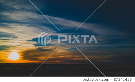 Vibrant beautiful winter sunset with angelic clouds Vibrant beautiful winter sunset with angelic clouds 87341436