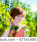 Portrait of a red-haired happy woman in park 87341480