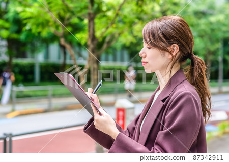 Business woman filling out a street questionnaire 87342911