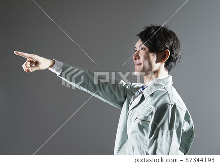 Worker pointing at a gray background Worker pointing at a gray background 87344193