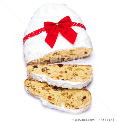 Sliced Traditional Christmas stollen cake with marzipan and dried fruit isolated on white background Sliced Traditional Christmas stollen cake with marzipan and dried fruit isolated on white background 87344421