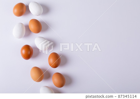 Overhead view of brown and white eggs arranged on table with empty space Overhead view of brown and white eggs arranged on table with empty space 87345114
