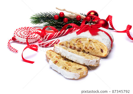 Sliced Traditional Christmas stollen cake with marzipan and dried fruit isolated on white background Sliced Traditional Christmas stollen cake with marzipan and dried fruit isolated on white background 87345792