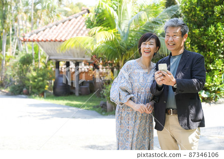 夫妻旅行-沖繩恩納村觀光 一邊用智能手機確認一邊觀光 87346106