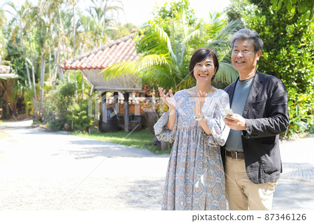Married couple trip-Sightseeing in Onna village, Okinawa Sightseeing while checking with a smartphone Married couple trip-Sightseeing in Onna village, Okinawa Sightseeing while checking with a smartphone 87346126